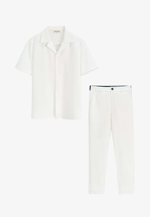 Chemise blanche à manches courtes avec boutons et col, et pantalon slim blanc assorti avec bouton noir et passants pour ceinture.