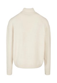 Maglione oversize color crema con colletto alto, polsini e orlo a costine, caratterizzato da una texture morbida e una vestibilità rilassata e squadrata.
