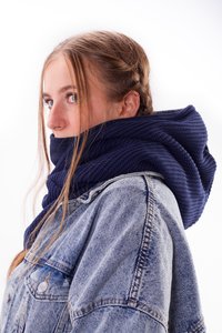 Navy knitted scarf with a textured pattern, worn loosely around the neck, paired with a light blue denim jacket.