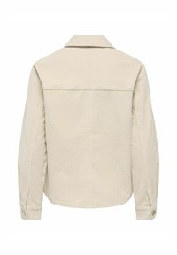 Veste beige en velours côtelé à manches longues vue de dos avec un col, une couture d'empiècement et des poignets boutonnés.