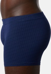 Mørkeblå boxershorts med et rutemønster, featuring en glat elastisk talje og strækstof for komfort og pasform.