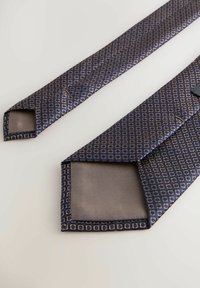Marineblauer Krawatte mit geometrischem Muster, das kleine Quadrate in Hellblau und Weiß zeigt. Hergestellt aus glattem Stoff mit spitzem Ende und gesteppten Kanten.