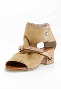 Bottine à bout ouvert en daim et cuir couleur fauve, avec un petit talon carré, une fermeture éclair latérale et une sangle décorative avec boucle en métal.