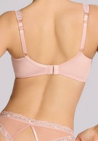 Jasnoróżowy biustonosz z regulowanymi koronkowymi ramiączkami i zapięciem na zatrzask. Gładki materiał o delikatnym połysku i brak fiszbin.