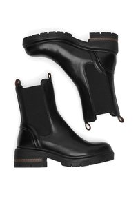 Melnas ādas potītes zābaki ar elastīgām sānu malām, kvadrātveida purngaliem un zemu profilu. Iezīmes ietver brūnas vilkšanas cilpas un dekoratīvu šuvumu uz papēža.