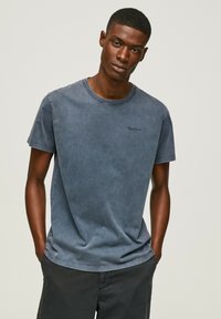Dark blue cotton t-shirt with a crew neck and short sleeves, featuring subtle "Pepe Jeans" embroidery on the chest. Soft, slight texture.