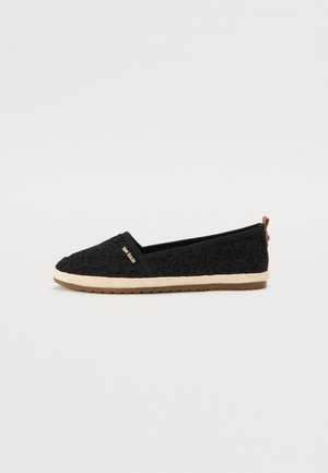 Scarpa slip-on nera in pizzo con tomaia testurizzata, lato elasticizzato e suola intrecciata beige. Presenta un piccolo accento marrone sul tallone.
