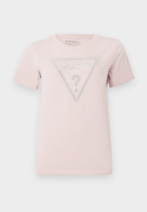Ljusrosa t-shirt i bomull med korta ärmar. Har en triangulär grafik med ordet "GUESS" och dekorativa rhinestones.