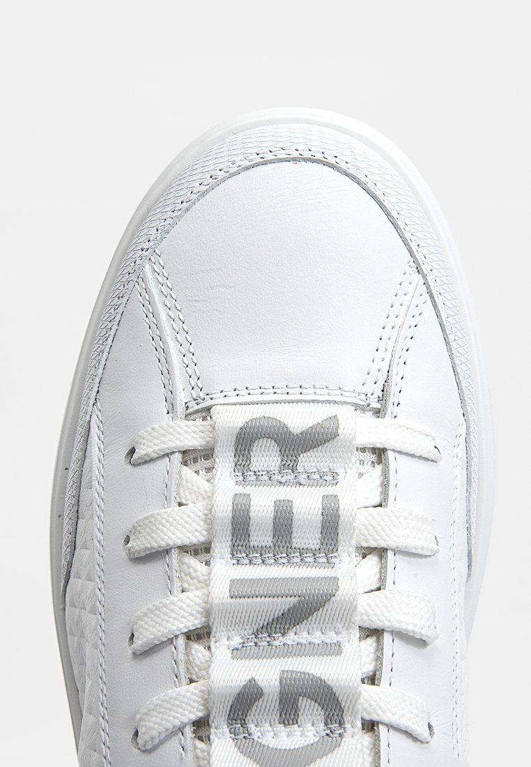 Weiße Sneaker mit einem Obermaterial aus glattem Leder, flachen weißen Schnürsenkeln, großem Logo auf der Zunge und strukturierten seitlichen Details. Abgerundete Schuhspitze.