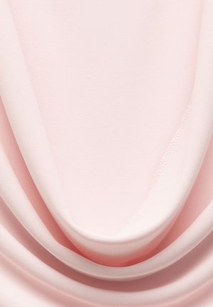 Lichtroze stof valt soepel, met een zachte textuur en een subtiele glans. De randen hebben een nette stiknaad, wat een vloeiende uitstraling benadrukt.