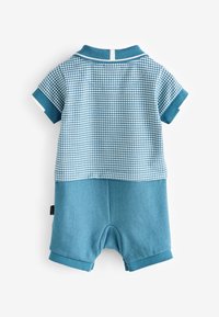 Kombinezon z krótkim rękawem w jasnoniebieskim i ciemnoniebieskim kolorze, z wzorem w kratę na górze oraz jednolitymi spodenkami, z kołnierzykiem polo.