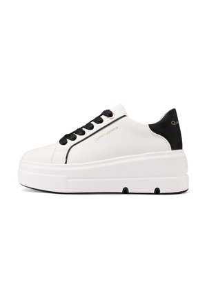 Sneaker bianco con suola spessa, dettagli neri sul tallone e sui lacci, materiale sintetico liscio e dettagli del logo dorato.