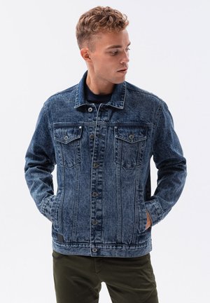 Denimjacke mit dunkelblauer Wäsche, klassischem Kragen, Knopfleiste, zwei Brusttaschen und seitlichen Taschen. Sie hat eine lockere Passform und sichtbare Nähte.
