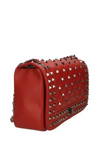 Borsa a tracolla in pelle rossa con texture trapuntata, dettagli argentati a borchie e tracolla a catena. Forma rettangolare con chiusura a patta e ferramenta metallica.