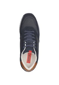 Basket de couleur bleu marine avec un cuir lisse et des détails en daim, bout rond, lacets noirs et un accent marron sur le talon. Doublure intérieure blanche.