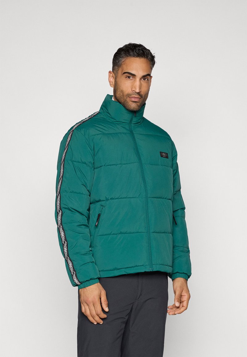 Πουκάμισο με επένδυση σε τιρκουάζ χρώμα, με ψηλό γιακά, φερμουάρ μπροστά και πλαϊνές τσέπες. Διαθέτει διακοσμητικό μοτίβο κατά μήκος των μανικιών. Απαλή υφή.