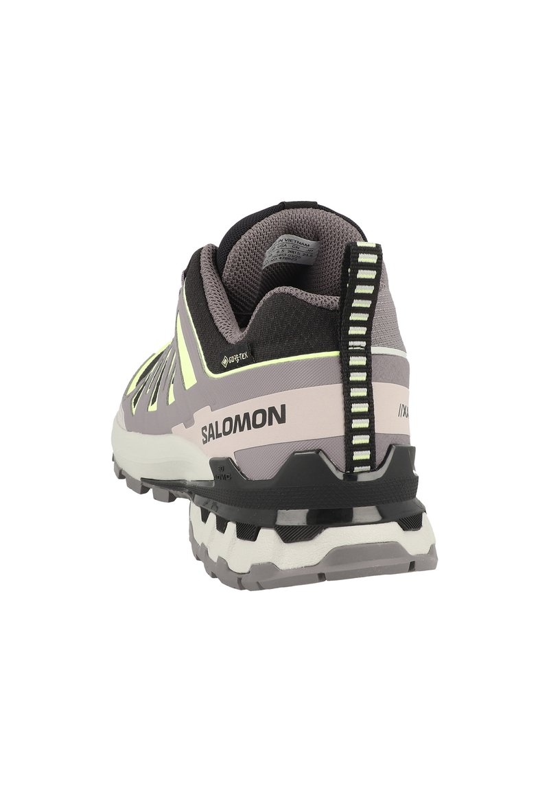 Scarpa da trail running Salomon in viola, nero e bianco. Presenta una parte superiore testurizzata, accenti riflettenti e una suola imbottita con tasselli prominenti.