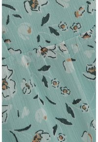 Tissu bleu clair avec petit imprimé floral blanc et marron et contours de feuilles noirs, avec une texture verticale subtile et une couture froncée.