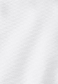 White textured fabric with subtle raised zigzag pattern, evenly lit, showing fine weave details and soft shadows.