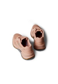 Par de zapatillas deportivas gruesas de color rosa con suelas gruesas y detalles de malla, vistas desde arriba sobre un fondo blanco.