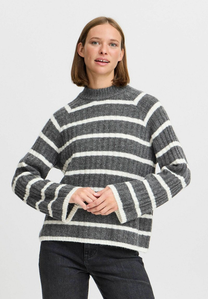 Pull rayé gris et blanc avec une texture côtelée, col montant et manches larges. Le matériel semble doux et chaud.