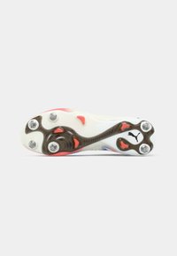 White and red soccer cleat sole with six metal studs and a black Puma logo near the heel, shown on a plain white background.
