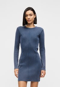 Μακρυμάνικο φόρεμα από τζιν σε σκούρο μπλε με κάθετη ραβδωτή υφή, εφαρμοστή γραμμή, στρογγυλή λαιμόκοψη και διακριτικές ραφές μπροστά.