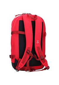 Zaino rosso caratterizzato da pannelli in rete nera, spallacci imbottiti regolabili e una parte superiore con zip. Include numerose cinghie e fibbie per la regolazione.