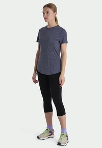 Navy blue athletic t-shirt with a crew neckline, paired with black capri leggings and multi-colored athletic shoes. Smooth, lightweight fabric.
