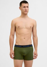 Olivgrüne Boxershorts mit einem schwarzen Bund und blauer Aufschrift "JACK & JONES". Aus weichem Stoff, mit körpernaher Passform und flachen Nähten.