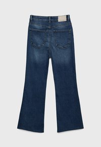 Jeans svasati in denim blu scuro con design a cinque tasche. Presentano una leggera scoloritura sulle gambe e un'etichetta beige sulla vita posteriore.