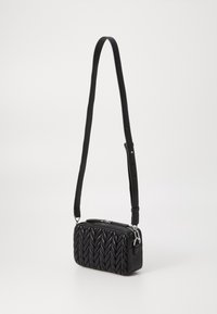 Borsa in pelle nera con motivo a treccia trapuntato, forma rettangolare e tracolla rimovibile. Accenti in hardware argentato sulla zip.