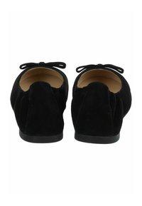 Ballerine in suede nero con punta rotonda, dotate di un retro morbido e di un piccolo fiocco decorativo su ciascun tallone. Suola in gomma, fodera interna liscia.
