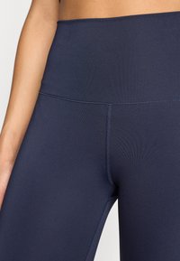 Ναυτικά κολάν με ψηλή μέση, κατασκευασμένα από απαλό, ελαστικό ύφασμα με υφαντό λάστιχο στη μέση και ενισχυμένες ραφές για αντοχή.