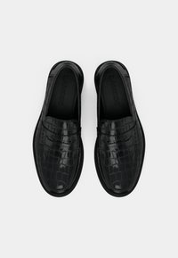 Čierne kožené mokasíny s krokodíľou textúrou, s klasickým dizajnom na vysúvanie a hladkým povrchom. Značka viditeľná vo vnútri.