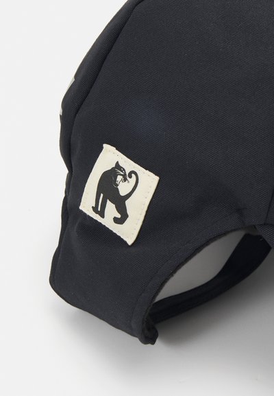 Black fabric pet harness with a stitched square patch featuring a black cat graphic. The design is simple and functional, with a durable texture.