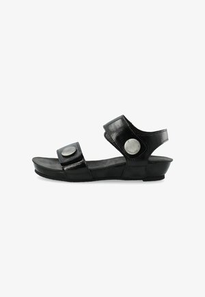 Black sandal with two adjustable straps, round metallic accents, and a cushioned insole. Textured leather finish and low wedge sole.
