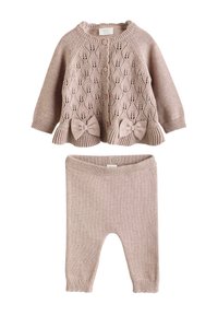 Cardigan en tricot rose pâle avec fermeture à boutons et accents en nœud, associé à un pantalon tricoté assorti. Présente des motifs de feuilles complexes et une texture côtelée.