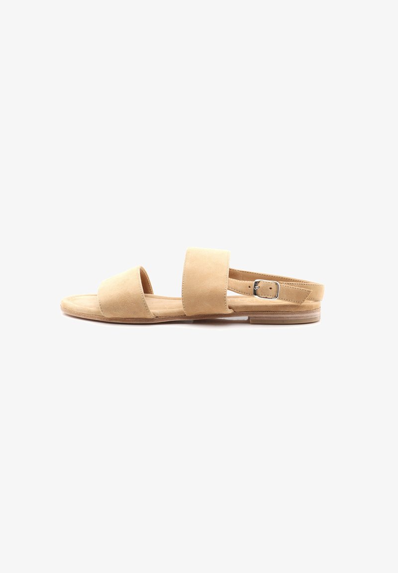Světlé nubukové sandály s plochou podrážkou, které mají dva široké pásky přes nohu a nastavitelný pásek kolem kotníku. Minimalistický design bez ozdob.