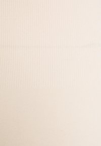 Tissu beige côtelé avec de fines rayures verticales et une texture lisse, mettant en valeur un éclat doux et des variations de couleur subtiles.