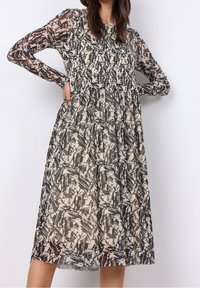 Langärmliges Kleid aus transparentem Stoff mit einem gemusterten Design in Beige- und Schwarztönen, einem gerafften Oberteil und einem fließenden Rock.