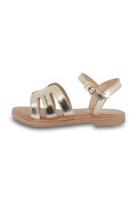 Las sandalias metálicas doradas cuentan con tres correas anchas con recortes, una correa trasera con hebilla y una plantilla en tono marrón sobre una suela plana.