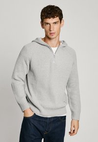 Hall griit triibuline sviiter, millel on lukuga kaelus ja kapuuts. Omab pikki varrukasid ja lahedat lõiget. Tekstuuriga kootud kangas koos peene logoga detailiga.