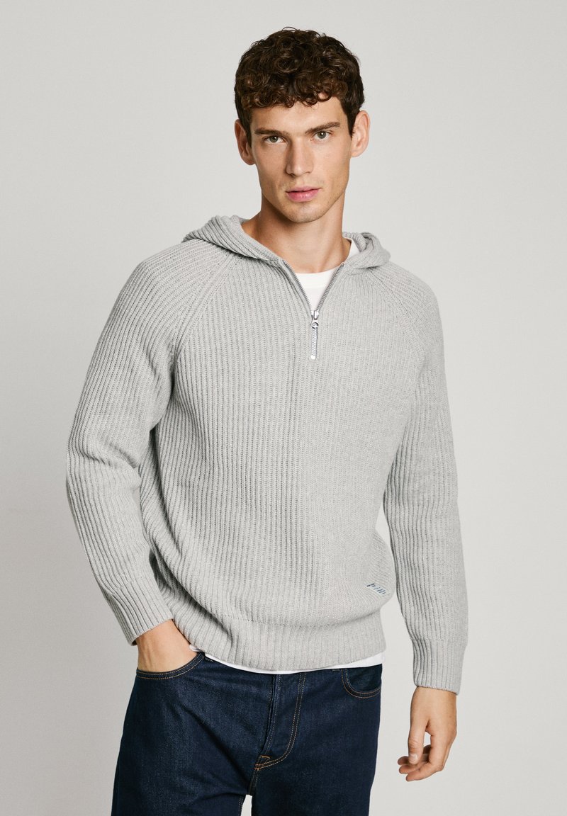 Hall griit triibuline sviiter, millel on lukuga kaelus ja kapuuts. Omab pikki varrukasid ja lahedat lõiget. Tekstuuriga kootud kangas koos peene logoga detailiga.