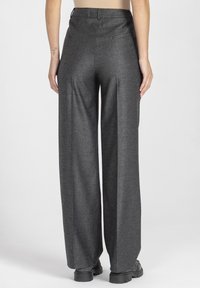 Ciemnoszare spodnie o szerokich nogawkach z teksturowanej tkaniny, z wysokim stanem, pętelkami na pasek i dwiema tylnymi kieszeniami. Proste, czyste linie.
