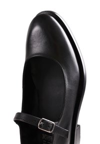 Chaussure Mary Jane en cuir noir avec bout rond et bride à boucle argentée, vue de dessus.