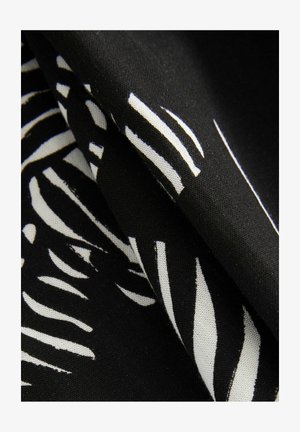 Černá látka se vzorem bílých pruhů, těsně složená, vykazující jemnou strukturu a hladký povrch.