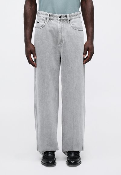Lys grå denim bukser med en avslappet, vid benskjæring. Har et klassisk fem-lommers design og en enkelt knappelukking.