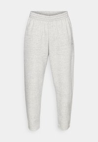 Ανοιχτό γκρι φόρμα με ελαστική μέση, στενές προς τα κάτω μπότες και απαλό υλικό. Διαθέτει μικρό λογότυπο στην αριστερή πλευρά.