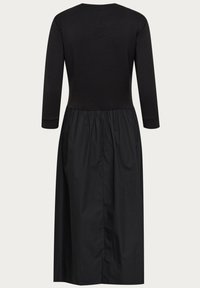 Schwarzes Kleid mit einem taillierten Oberteil und langen Ärmeln, übergehend in einen gerafften, leicht strukturierten Rock, mit rundem Ausschnitt.